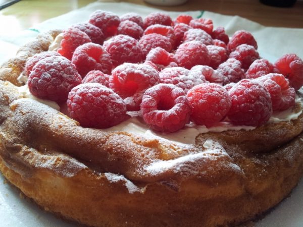 Classica cheesecake al forno con panna e lamponi