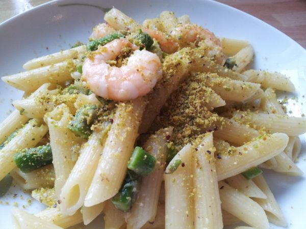 Penne con asparagi, gamberi cosparsi di pistacchio